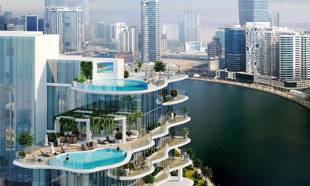 Luxury high-rise with terraced pools and greenery overlooking a river in a modern cityscape.