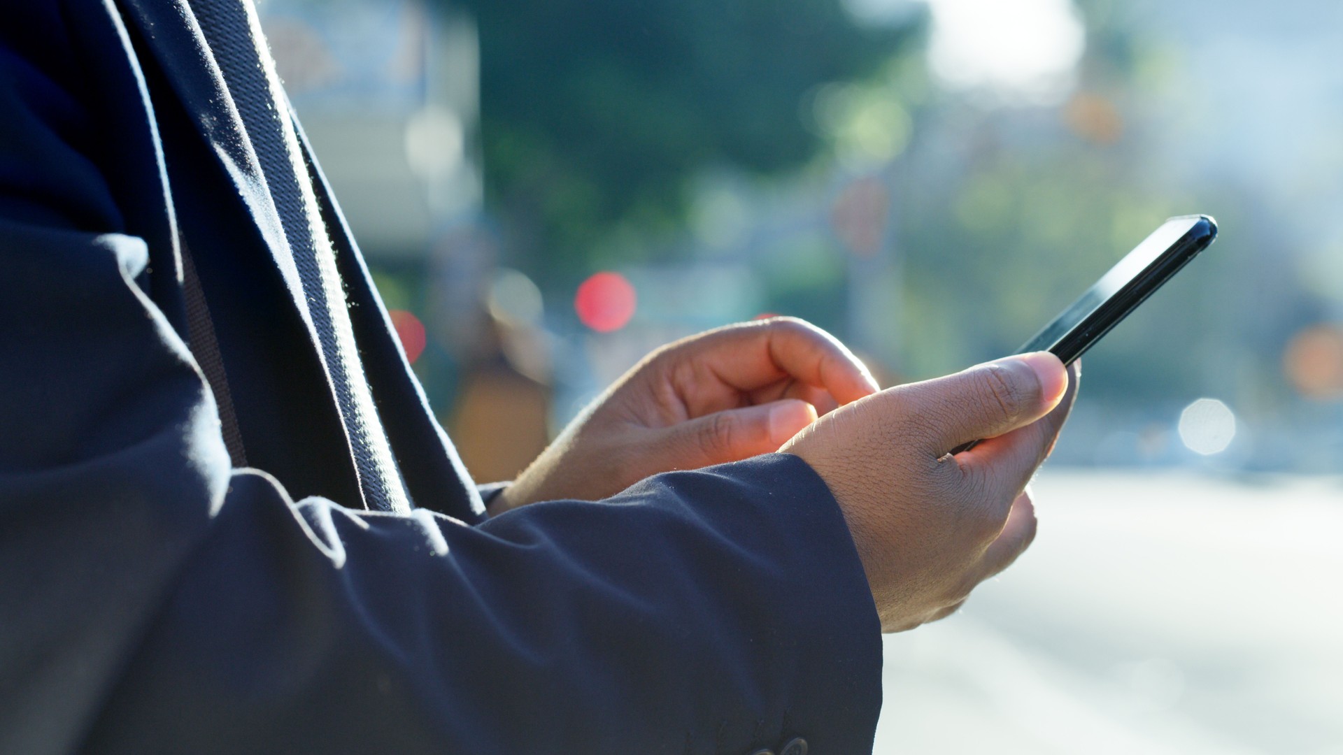 Phone, hands and businessman in the urban city standing in the street waiting for lift, cab or taxi. Technology, mobile and professional employee typing message or networking on social media in town.