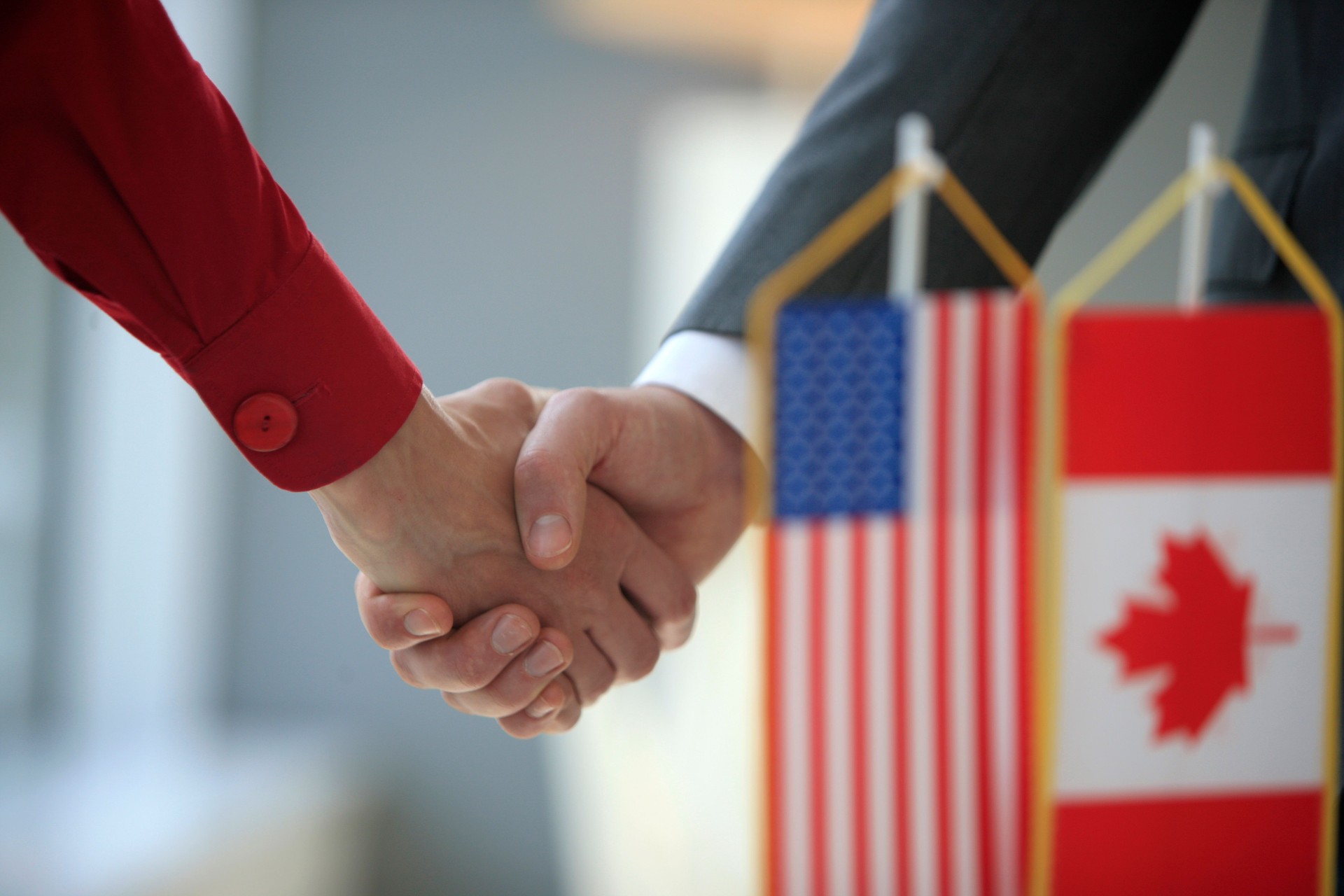 Handshake in front of usa and canada flags