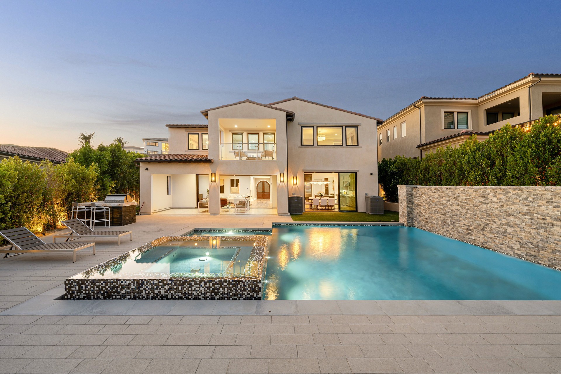 Luxurious modern house with swimming pool at dusk.